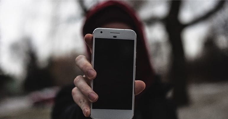 Woman with face hidden holding out phone