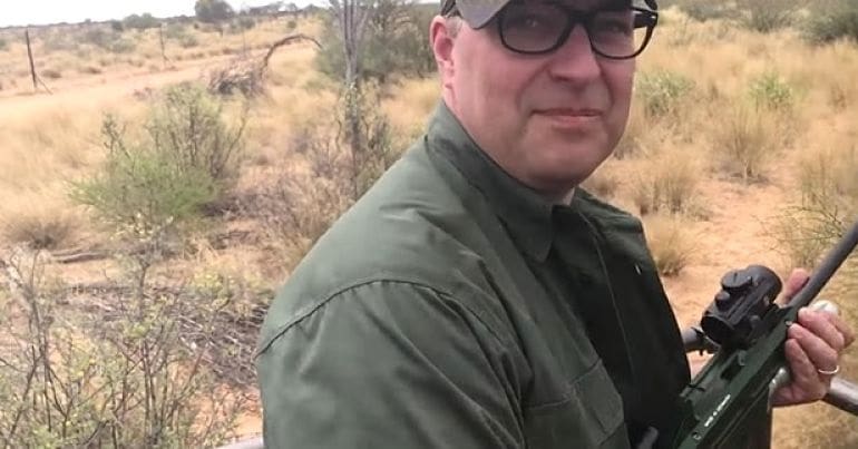 A British hunter smiles for the camera as he stalks a lion in South Africa