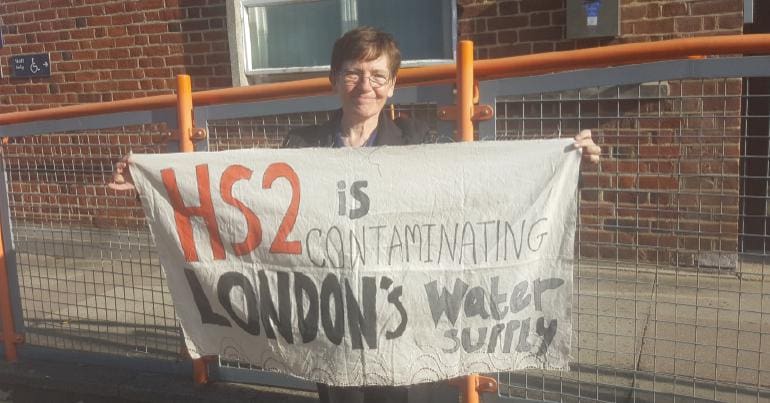 Sarah Green holding a banner which reads "HS2 is contaminating London's water"