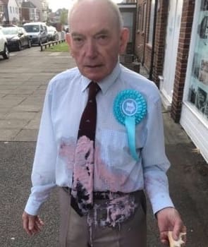 A Brexit Party activist supposedly covered in milkshake outside a polling station. Also pictured two milkshakes