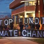 A banner that reads 'stop funding climate change\