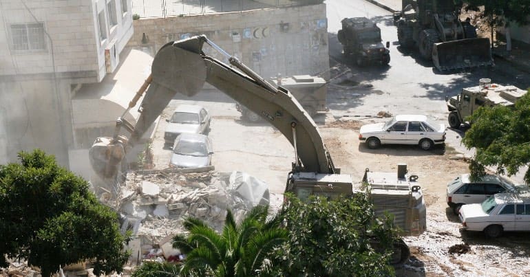 A bulldozer levelling a Palestinian home.