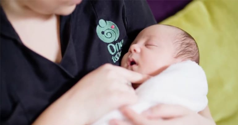 One to One midwife holding a newborn baby
