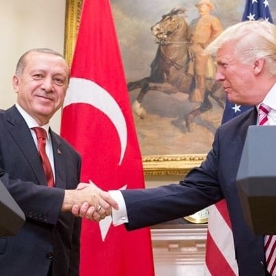 Donald Trump and Recep Tayyip Erdoğan shaking hands in front of US and Turkish flags