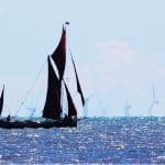 A Thames barge sailing in front of an offshore wind farm
