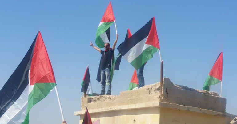 Palestinians occupy the roof of a building during a protest on the Dead Sea coast