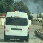 An ambulance surrounded by destruction and smoke rising in Ras al Ayn on 20 October