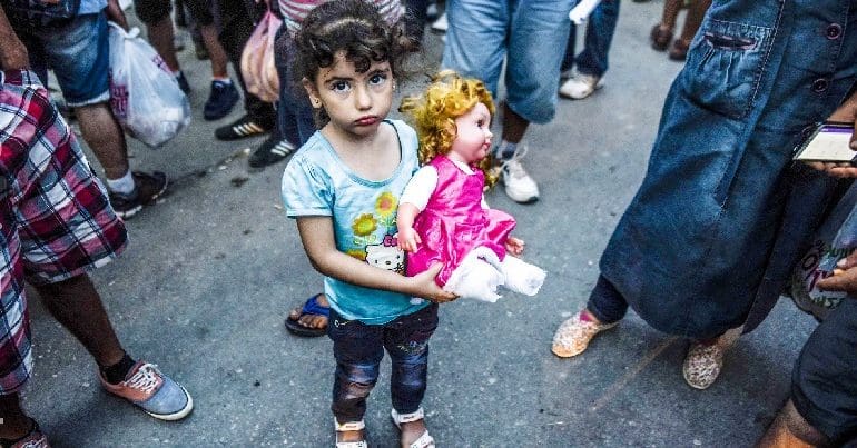 Syrian girl holding doll in a refugee camp in Serbia