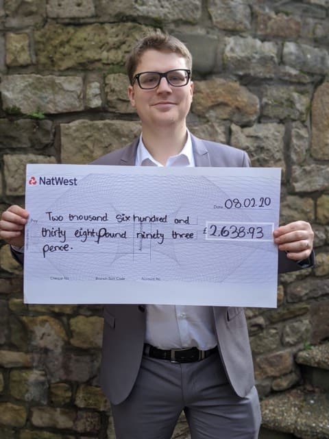 Joshua Brandwood with a cheque for Wakefield foodbank