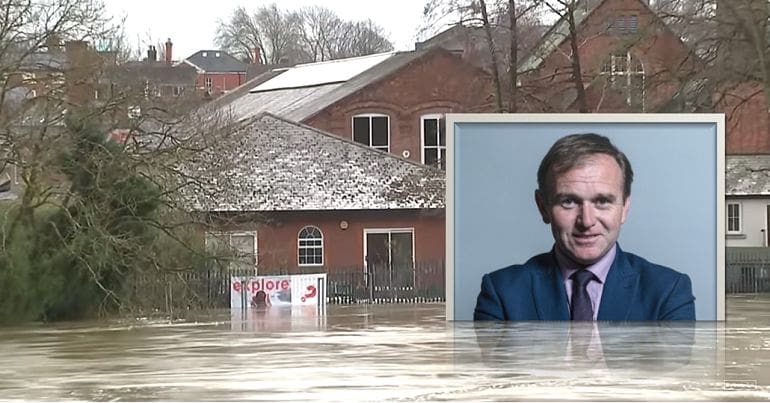 A picture of George Esutice submerged in floodwater