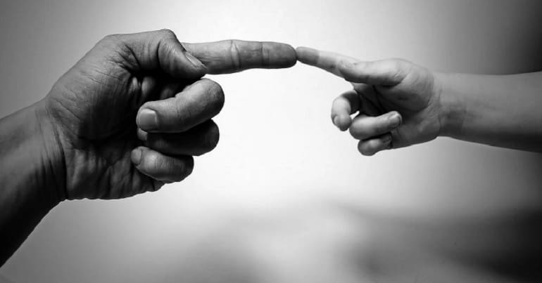 Two hands touching combating loneliness