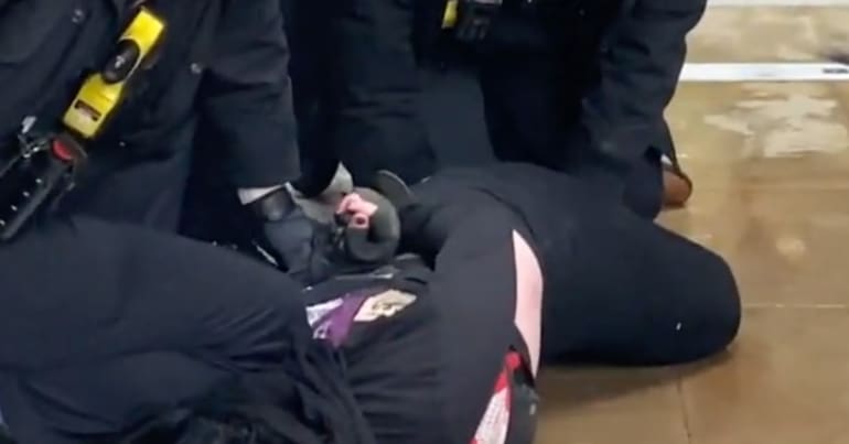 Police kneel on protester's neck during arrest