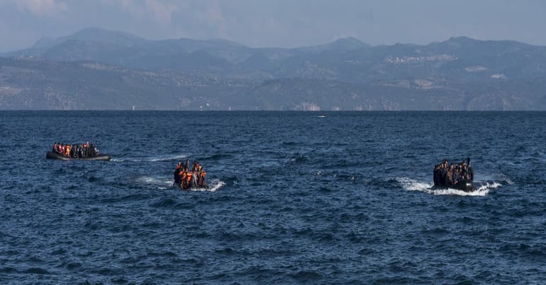 3 boats with refugees are arriving to the beaches of Skala Sykamia, in the background you can see another 2 boats, Lesvos island, Greece (photo taken in 2015)