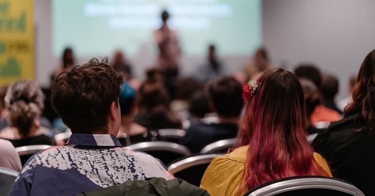 People sat listening to a speaker at a debate