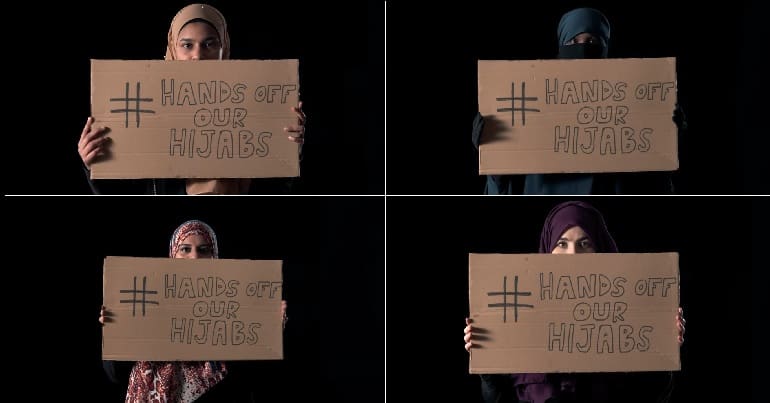 Muslim women holding placard saying '#HandsOffOurHijabs'