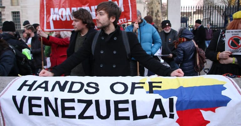 Protest banner that reads 'hands of Venezuela'