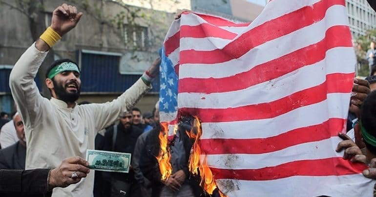 Iranian protesters burning a US flag