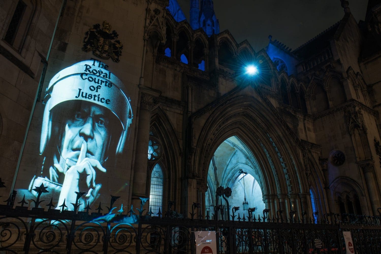 Riot police officer demanding silence projected onto Royal Courts of Justice-min-min