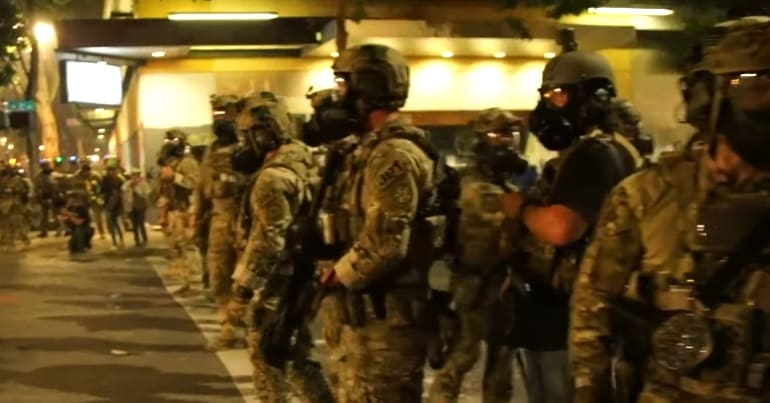 Armed federal agents block a street in Portland, Oregon