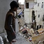 Child standing above building debris in Sanaa, Yemen