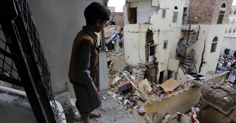 Child standing above building debris in Sanaa, Yemen