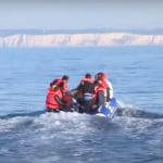 A group of refugees crammed into a small dinghy that's travelling across the Channel
