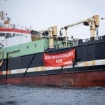 A super trawler with a Greenpeace banner hanging off it that reads: 'BAN SUPERTRAWLERS NOW!'