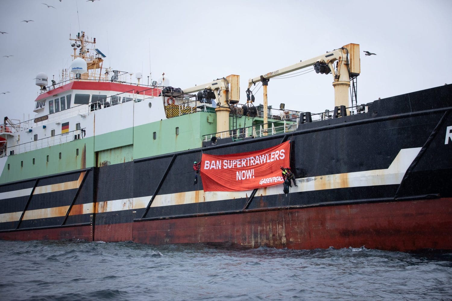 A super trawler with a Greenpeace banner hanging off it that reads: 'BAN SUPERTRAWLERS NOW!'