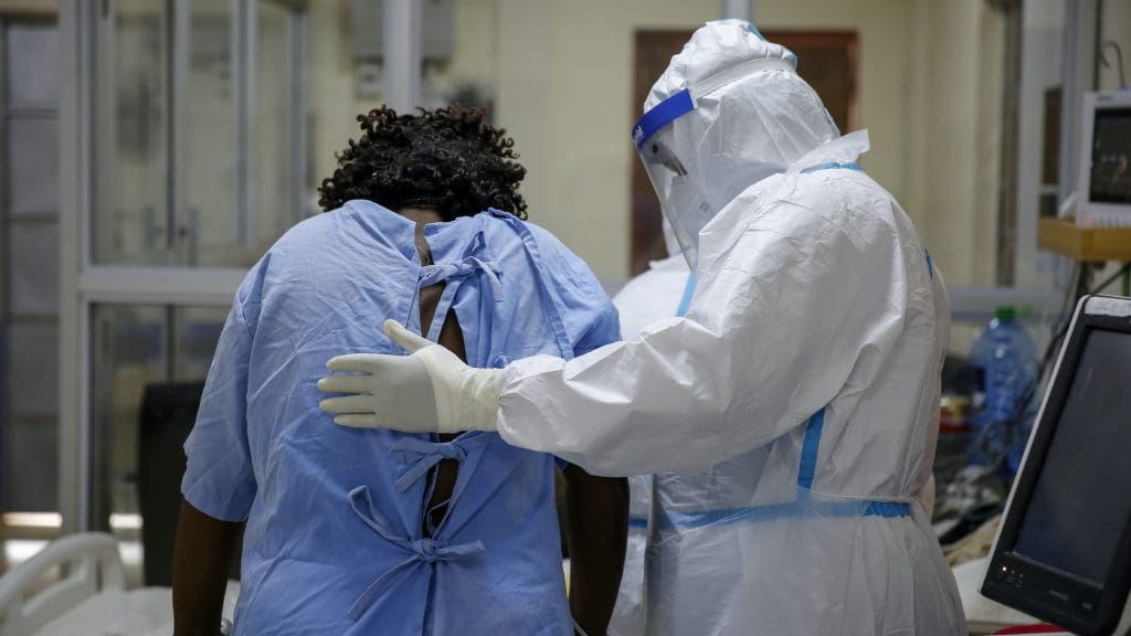 A patient with a doctor wearing a full suit of PPE