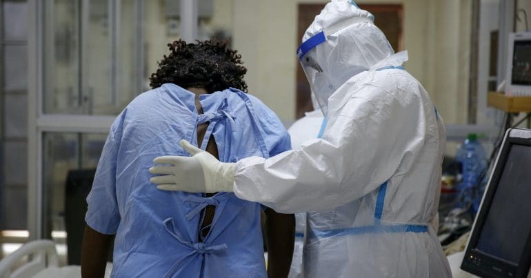 A patient with a doctor wearing a full suit of PPE