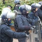 Riot police holding shields