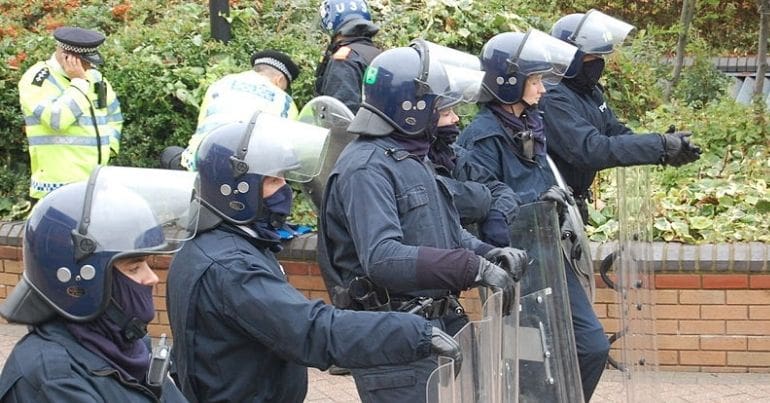 Riot police holding shields