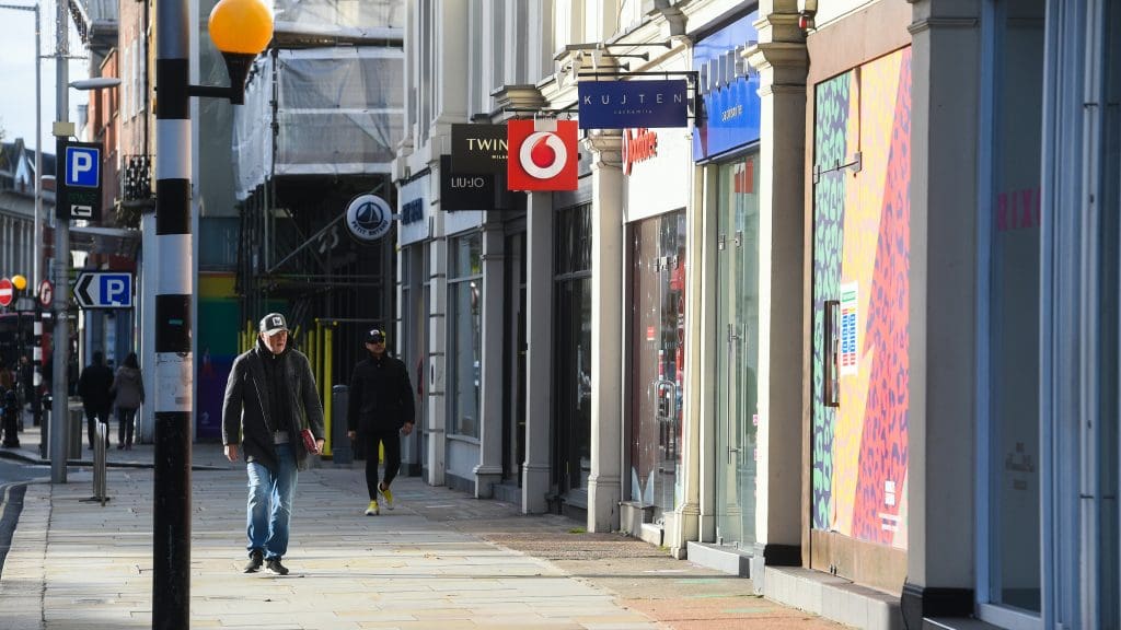 A high street with people walking down it