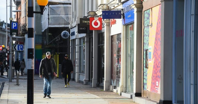 A high street with people walking down it