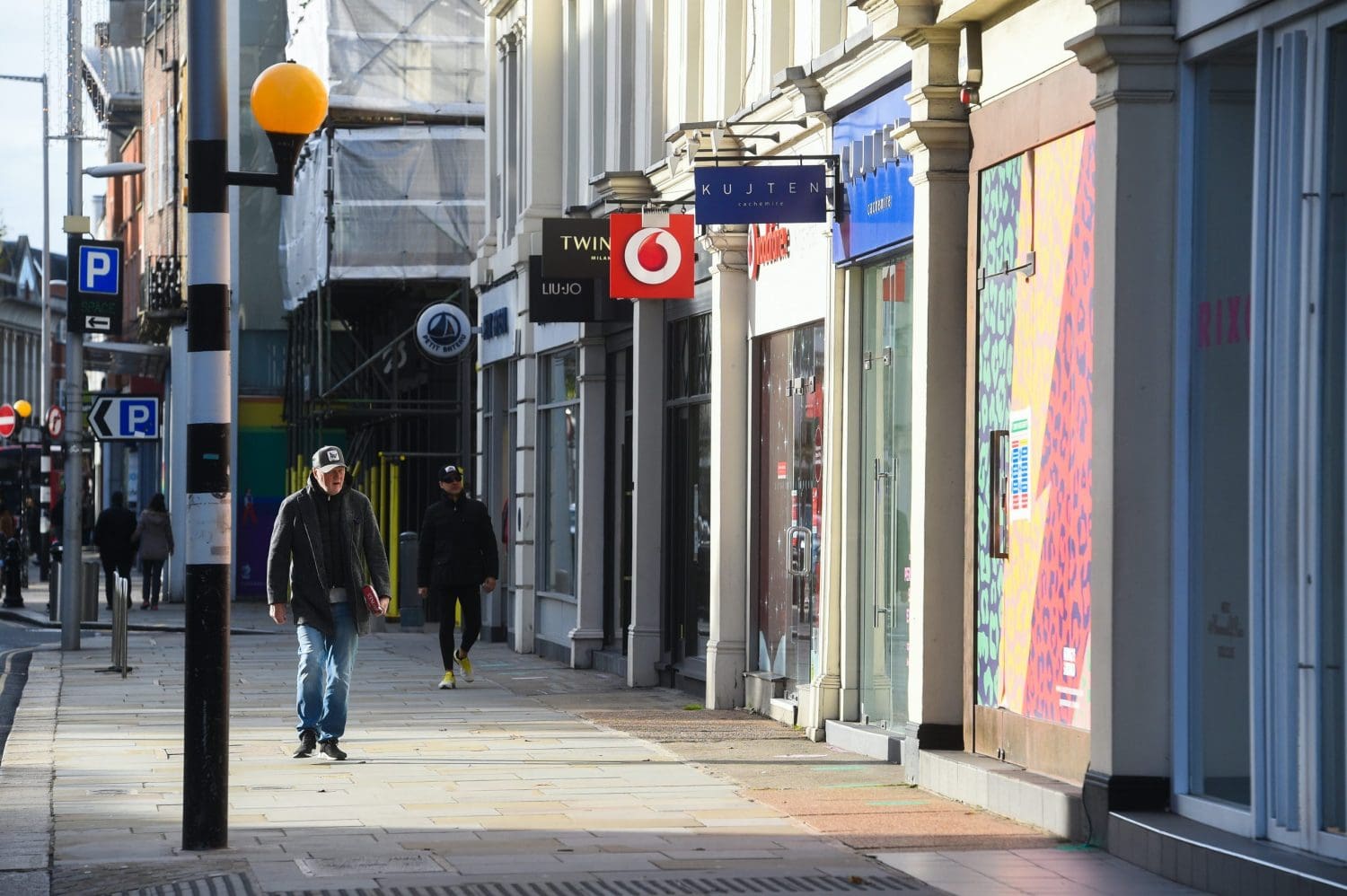 A high street with people walking down it