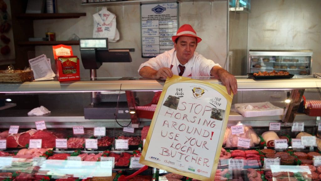 A Scottish butcher putting out a sign