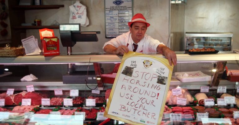 A Scottish butcher putting out a sign