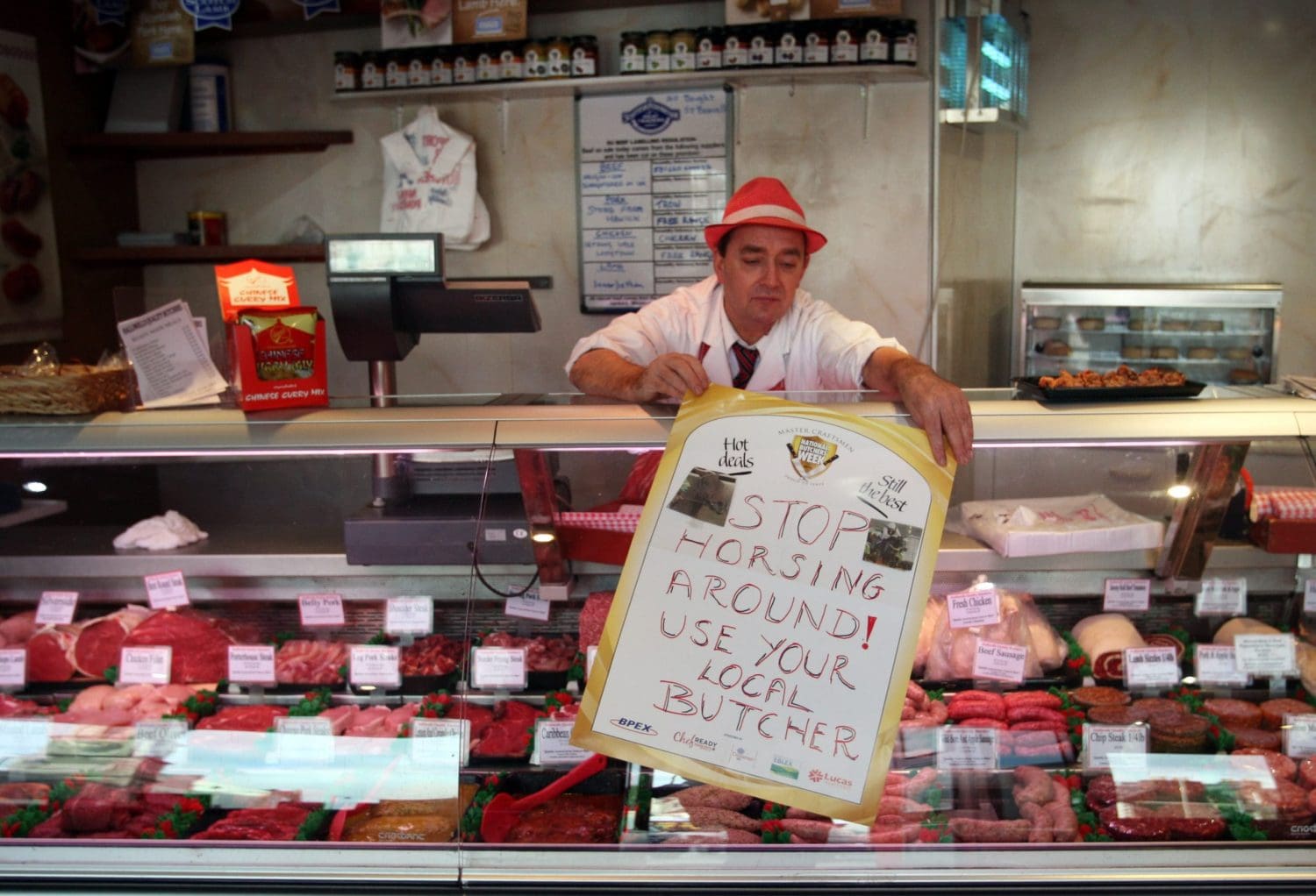 A Scottish butcher putting out a sign