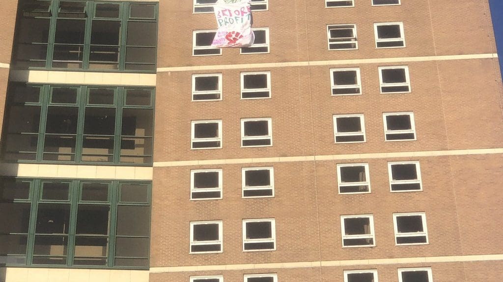 A protest banner hanging outside of an occupied student building