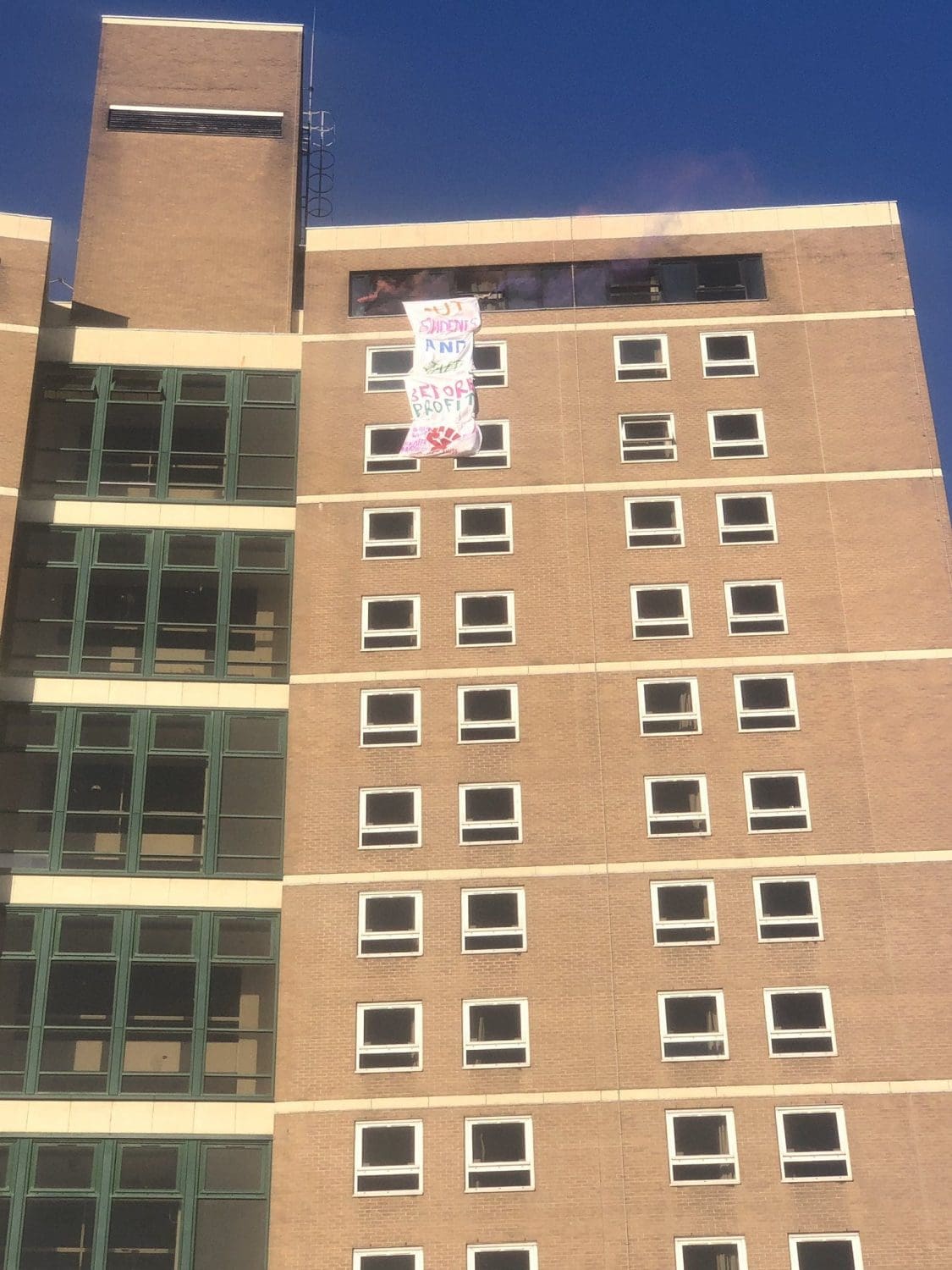 A protest banner hanging outside of an occupied student building
