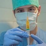 A doctor hold a needle up
