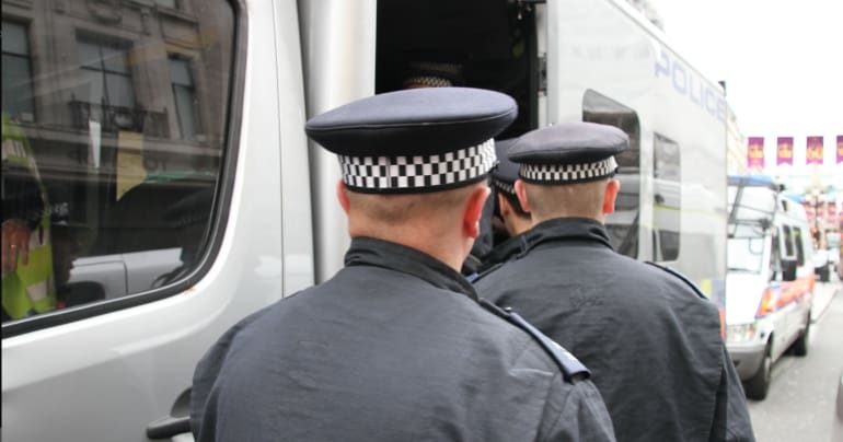 Police officers by a van