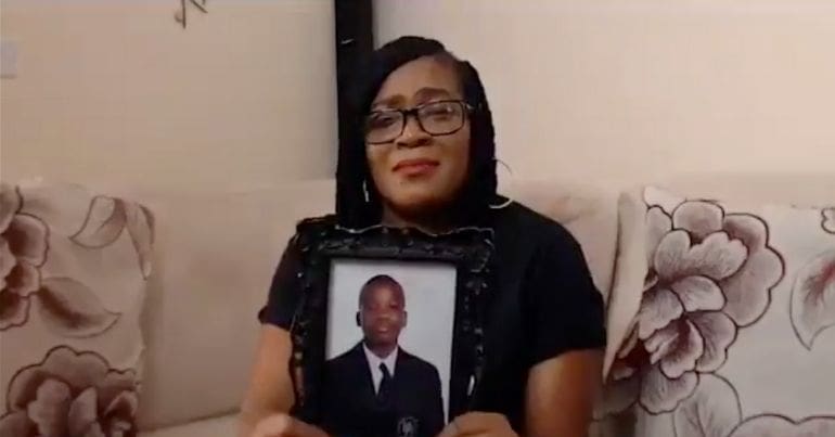 Osime Brown's mother holds a framed photo of her son