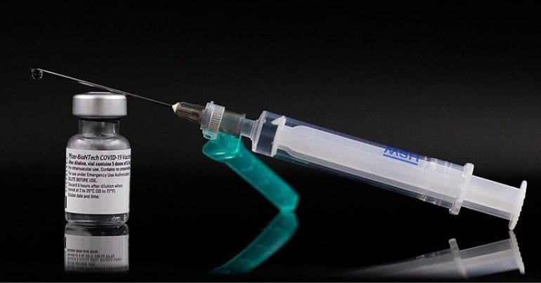 A syringe and a bottle of medicine