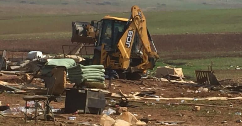 A Jcb machine being used during demolitions in Humsa