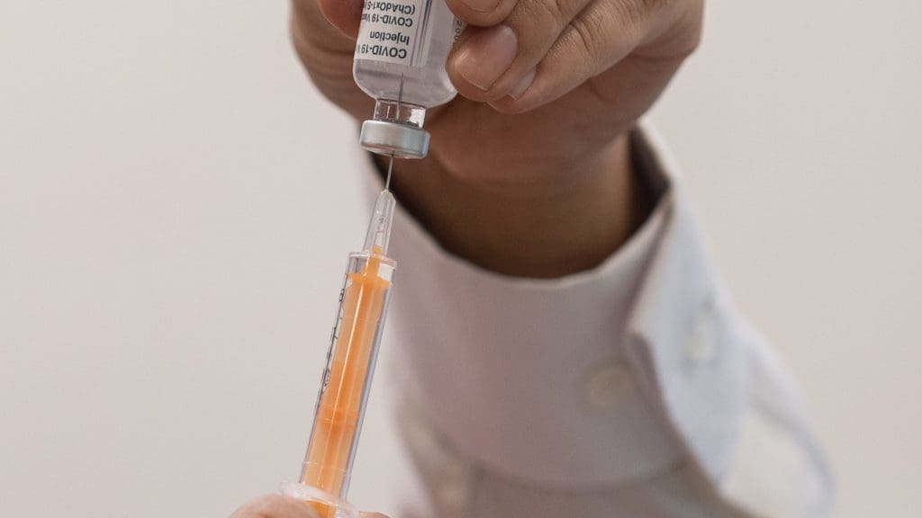 A syringe and a bottle of vaccine