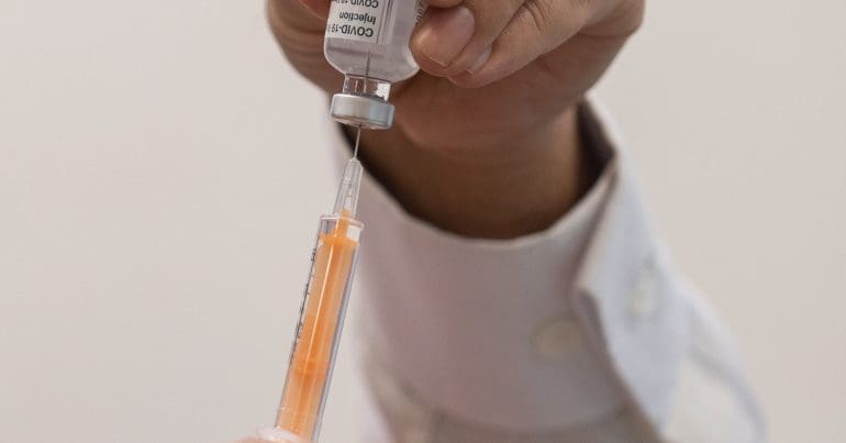 A syringe and a bottle of vaccine