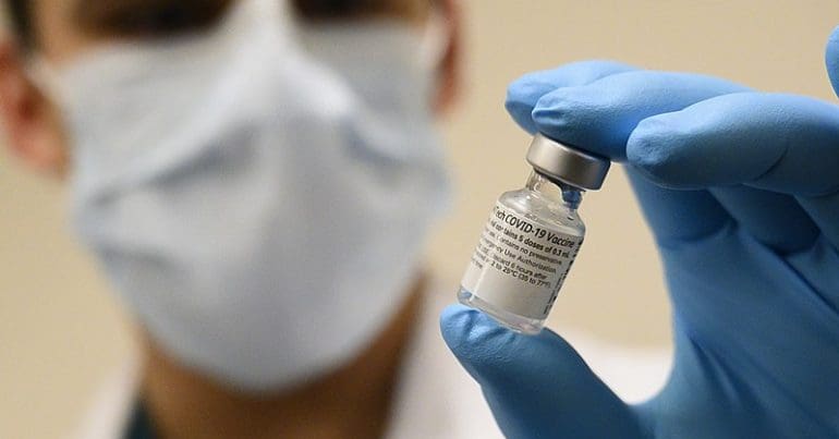 A scientist holding a vaccine vial