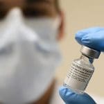 A scientist holding a vaccine vial