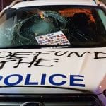 A police car emblazoned with the words 'Defund the Police'